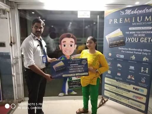 Branch staff handing a Mahendra's Premium membership card to a student at Bhootnath
